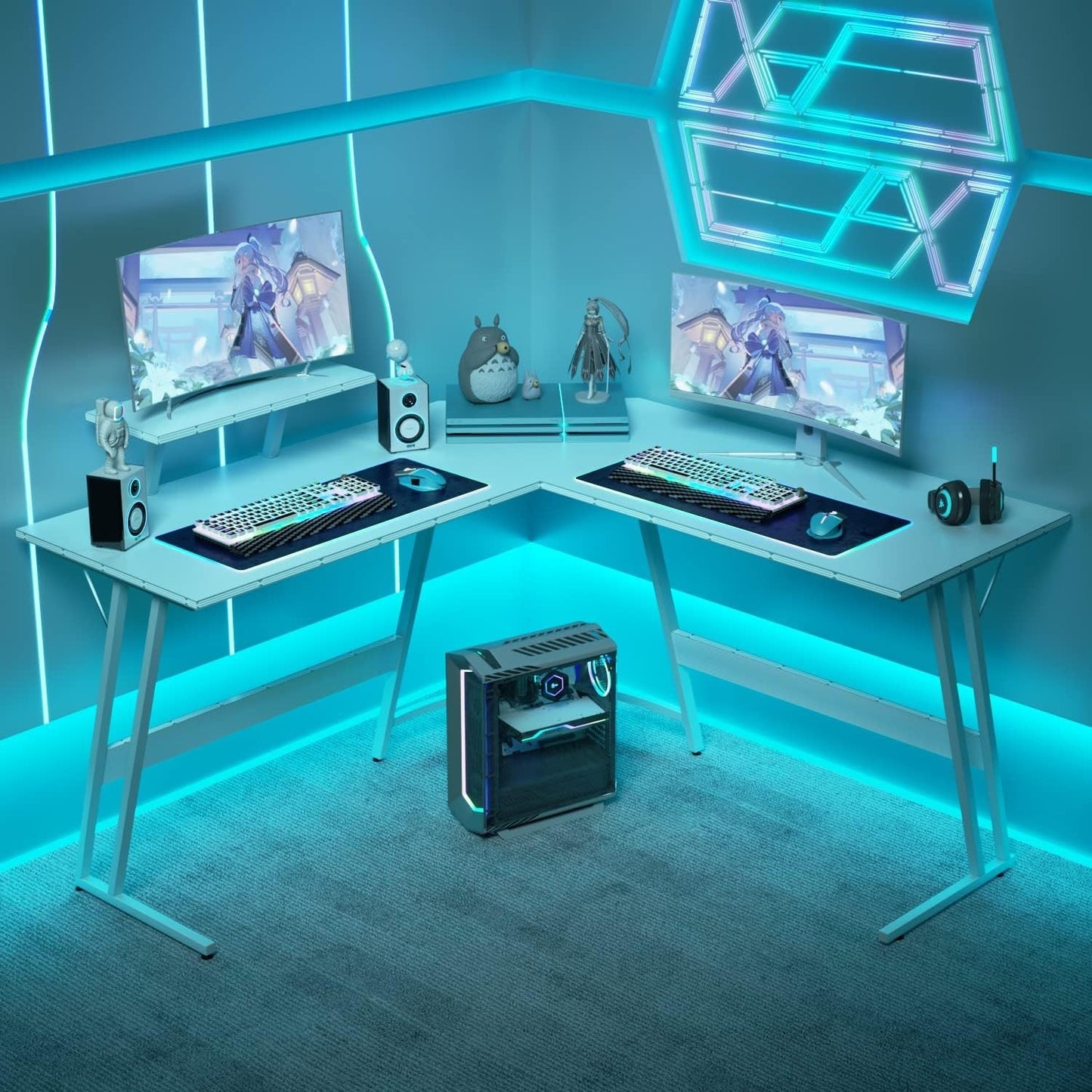 L shaped gaming desk setup with dual monitors, gaming accessories, and ambient LED lighting in a modern room.